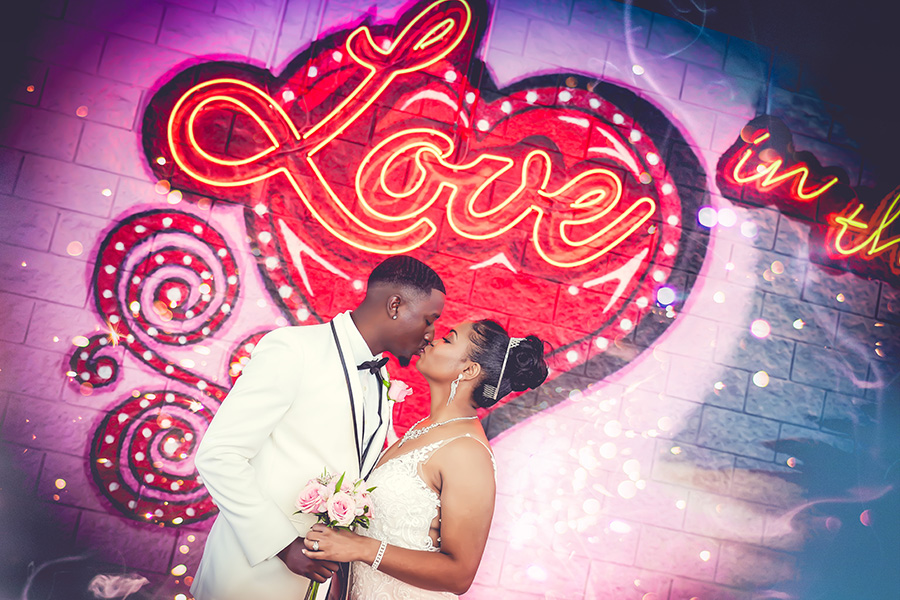 Groom and bride stating in front of a Las Vegas mural on their wedding day